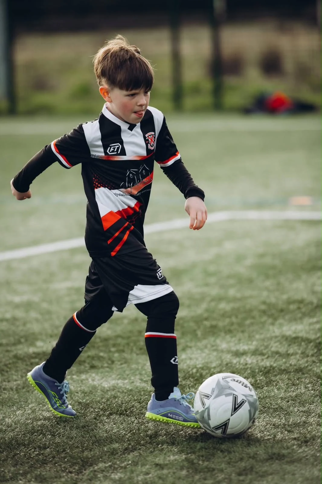 Young player in FTACT kit moving with the ball during a match