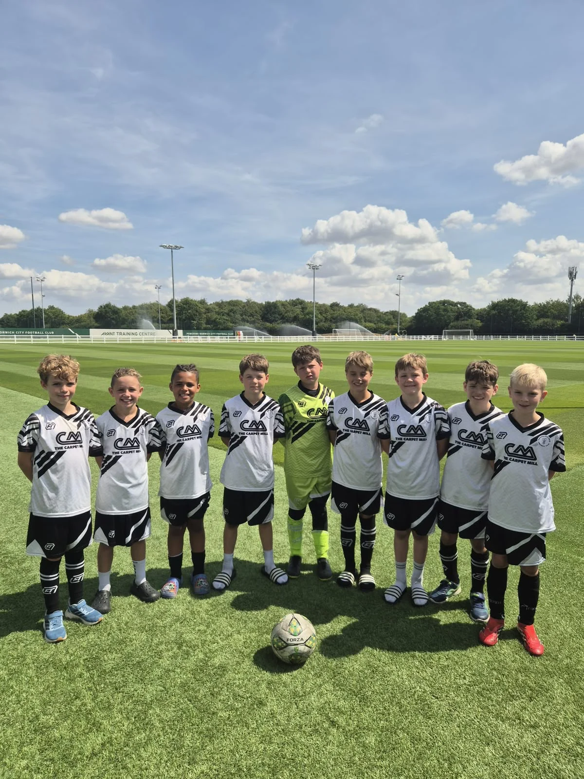 Junior team together in white and black FTACT match kit